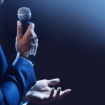 Medical staffing professional delivering a confident speech on stage with a microphone.