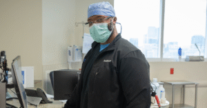 Surgical team member stands confidently at a workstation, representing operating room staffing leadership and professionalism in operating room staffing.
