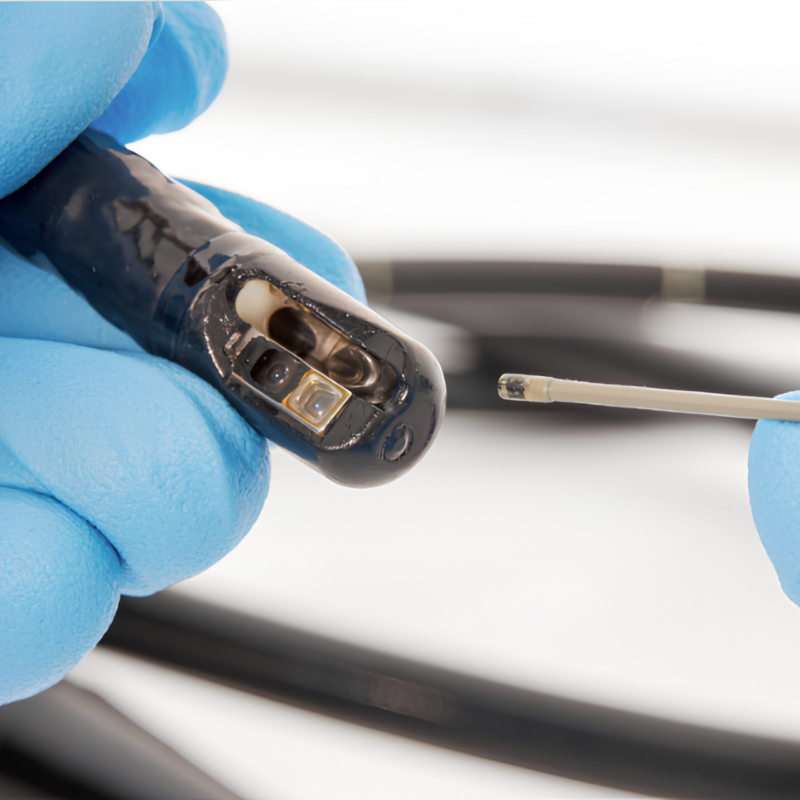 Borescope inspection of a lumened surgical instrument revealing potential damage, debris, discoloration, and moisture inside an internal channel.